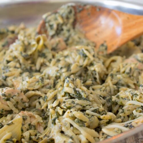 spinach artichoke orzo stirred in a pan