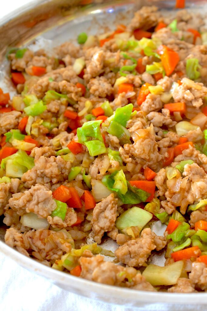 overhead view of asian ground chicken in a stainless steel pan