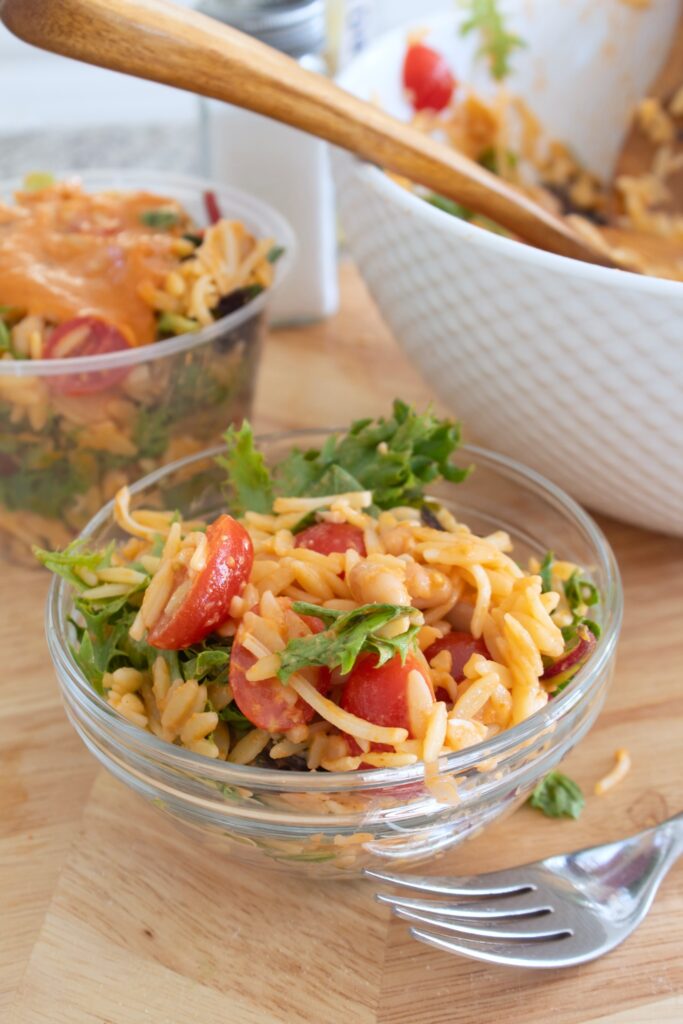 small clear bowl full of orzo pasta salad sun-dried tomato