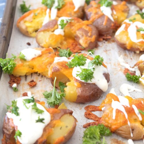 sheet pan with smashed ranch potatoes and parsley garnish