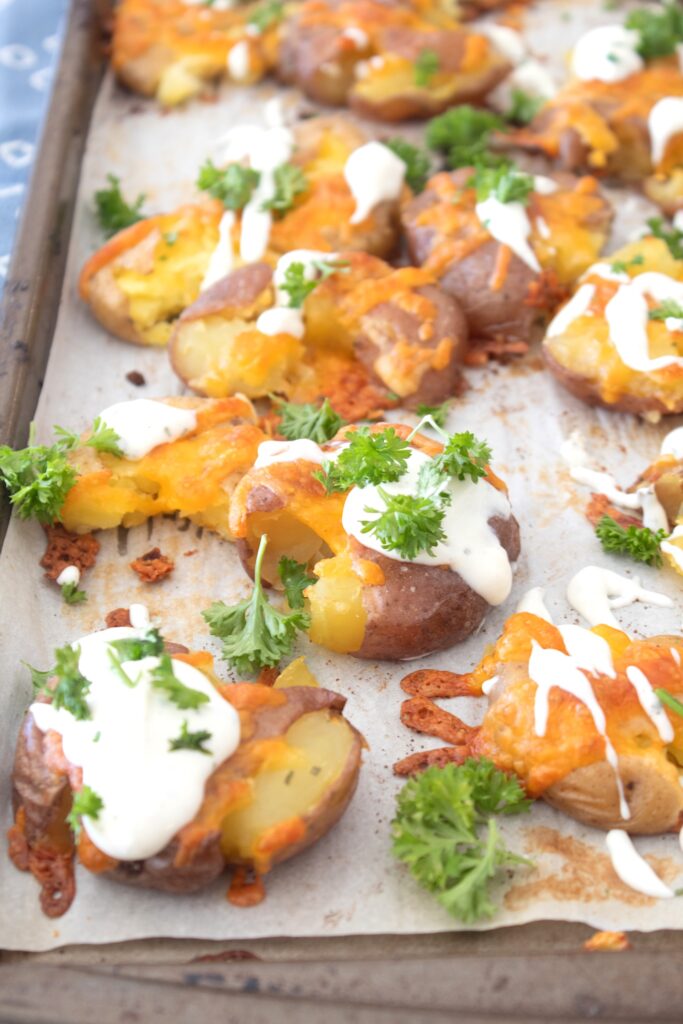 sheet pan with smashed ranch potatoes and parsley garnish