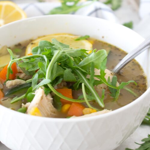 bowl of summer minestrone soup with arugula garnish