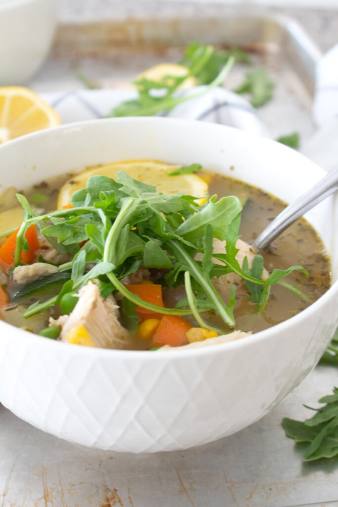 bowl of summer minestrone soup with arugula garnish