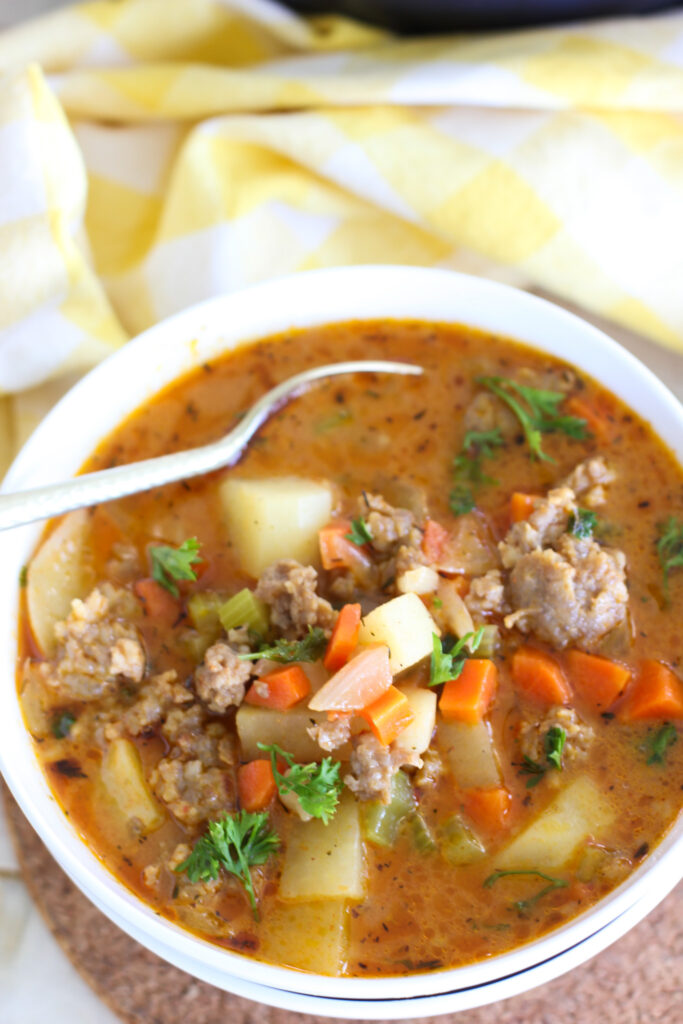 Sausage and Potato Soup ready to serve in a white bowl